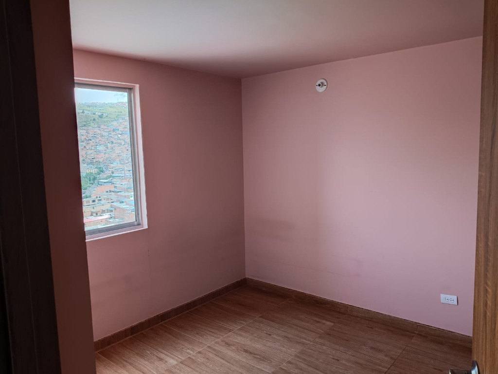 Alcoba con vista exterior y piso en cerámica tipo madera El Perdomo