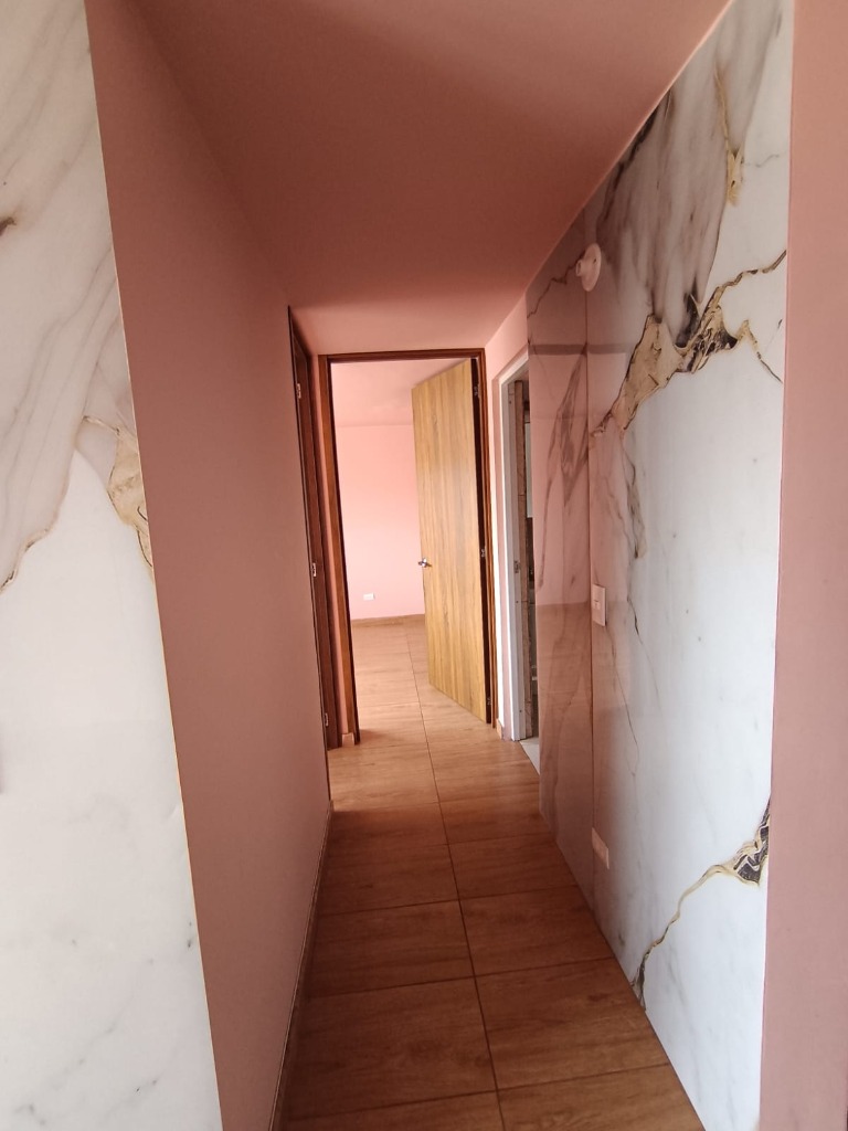Pasillo con elegantes acabados en mármol y puertas en madera El Perdomo