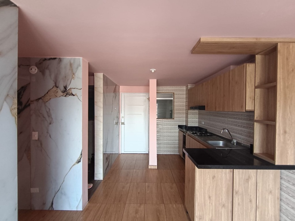 Zona social con cocina abierta, barra americana y acabados modernos El Perdomo