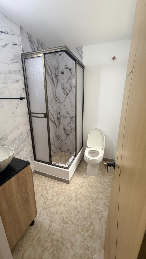 Baño moderno con ducha y acabados tipo mármol Teusaquillo